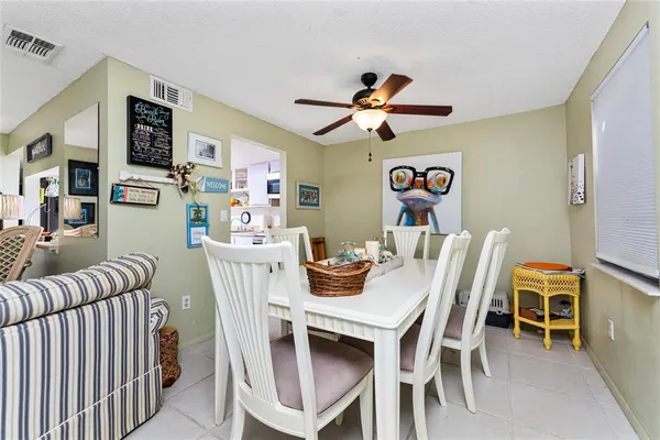 a view of a dining room with furniture and a chandelier fan