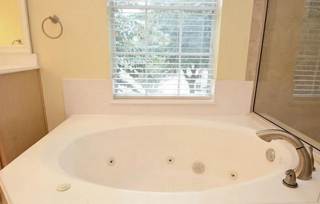 a white bath tub sitting in a bathroom next to a window