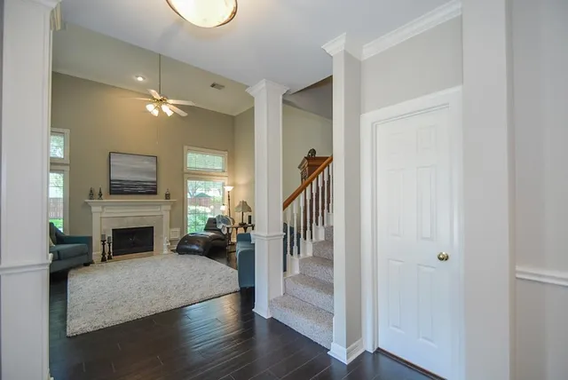 a view of a livingroom with a fireplace wooden floor and staircase