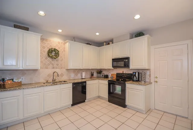 a kitchen with white cabinets stainless steel appliances and a sink