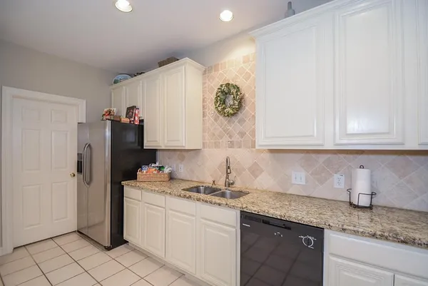 a kitchen with stainless steel appliances granite countertop a sink and a refrigerator