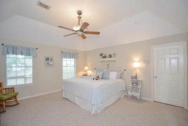 a bedroom with a bed a chandelier and a window