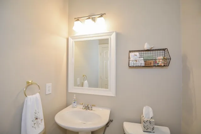 a bathroom with a toilet a sink and mirror