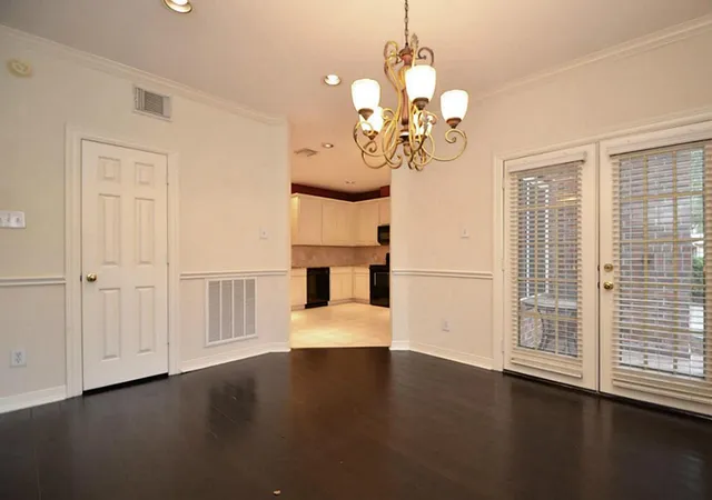 a view of a livingroom with a chandelier wooden floor windows and a chandelier fan