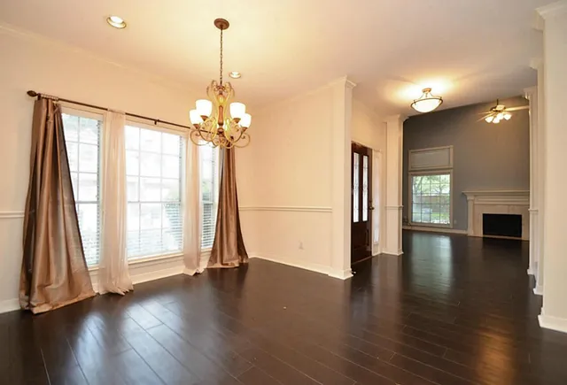 a view of empty room with wooden floor and fireplace