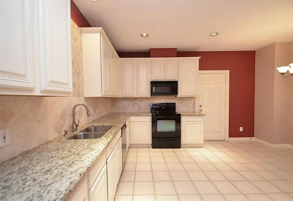 a kitchen with stainless steel appliances granite countertop a sink and a stove