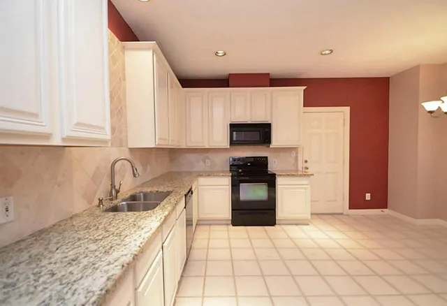 a kitchen with stainless steel appliances granite countertop a sink and a stove