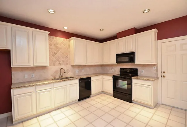 a kitchen with white cabinets stainless steel appliances and sink