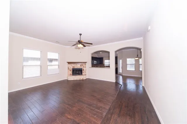 a view of a livingroom with wooden floor and a kitchen space