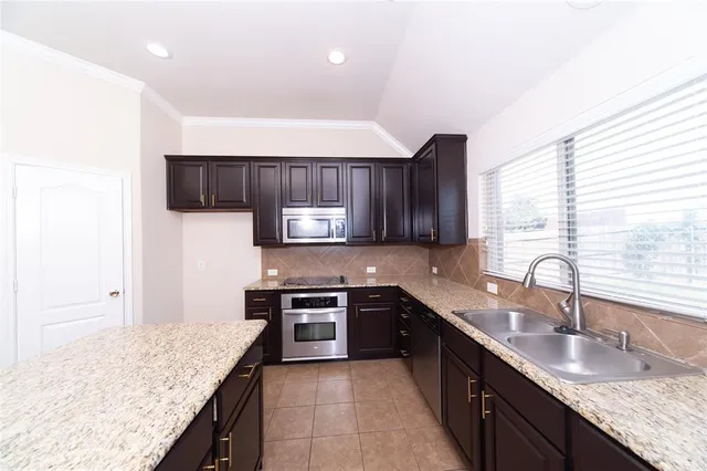 a kitchen with stainless steel appliances granite countertop a sink stove and cabinets