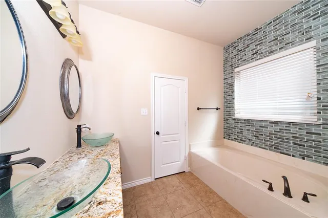 a bathroom with a tub sink and mirror
