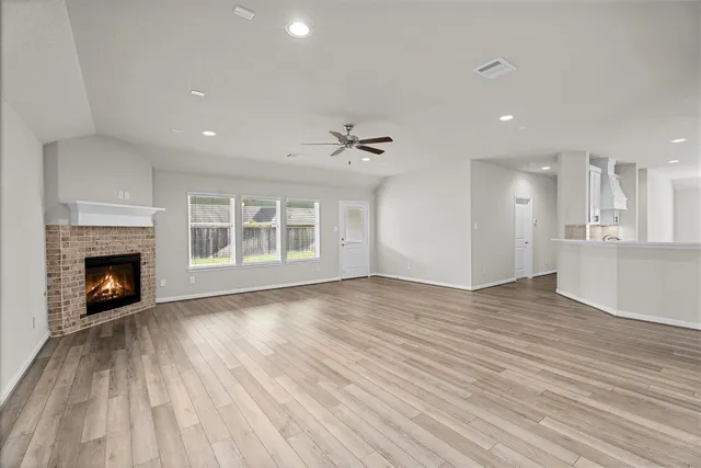 a view of an empty room with a fireplace and a window