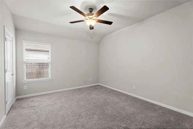 an empty room with a window and a ceiling fan