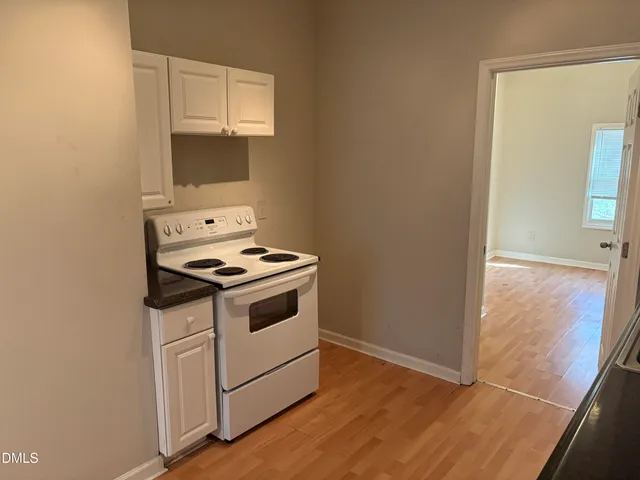 a kitchen with granite countertop white cabinets and black appliances