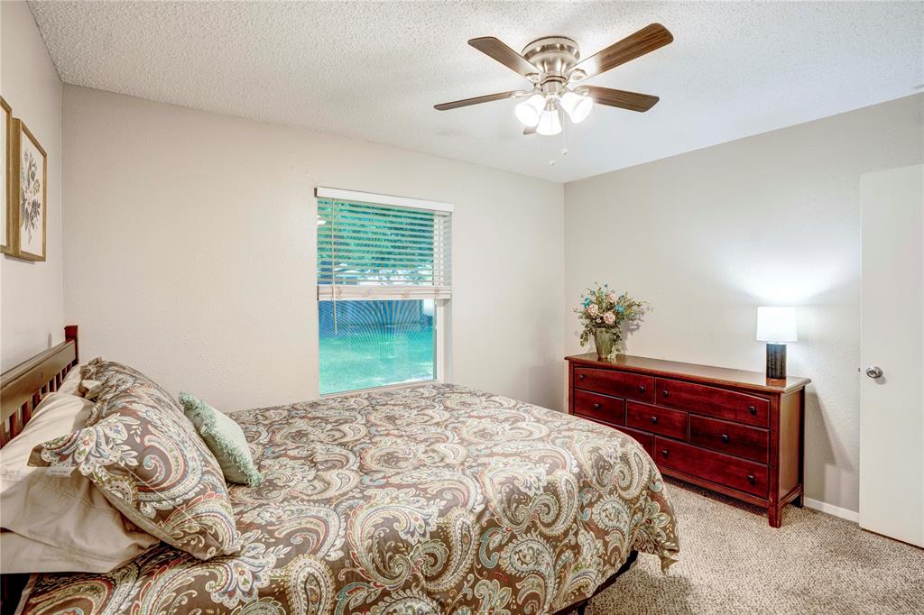 6028 Ridgecrest Drive Watauga, TX 76148 - Photo 20 of 40 a bedroom with a bed and a chandelier