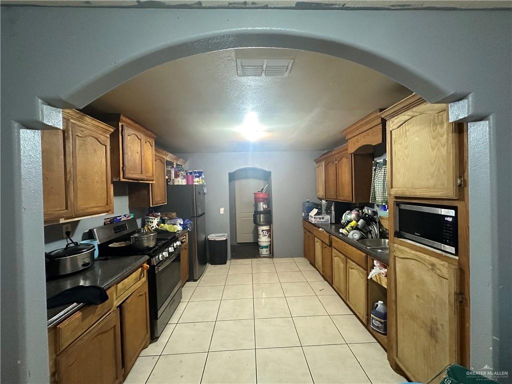 801 Earling Road Donna, TX 78537 - Photo 7 of 10 a kitchen with stainless steel appliances a sink stove and refrigerator