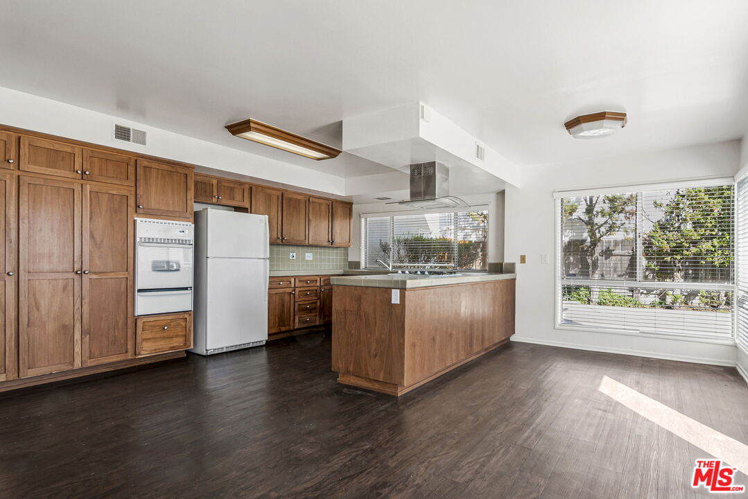 2695 Cordelia Road Los Angeles, CA 90049 - Photo 11 of 33 a kitchen with refrigerator cabinets and wooden floor