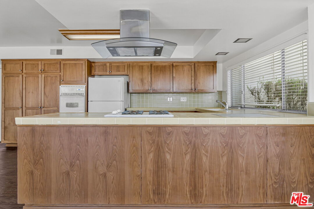 2695 Cordelia Road Los Angeles, CA 90049 - Photo 13 of 33 a kitchen with kitchen island a stove a sink and a window
