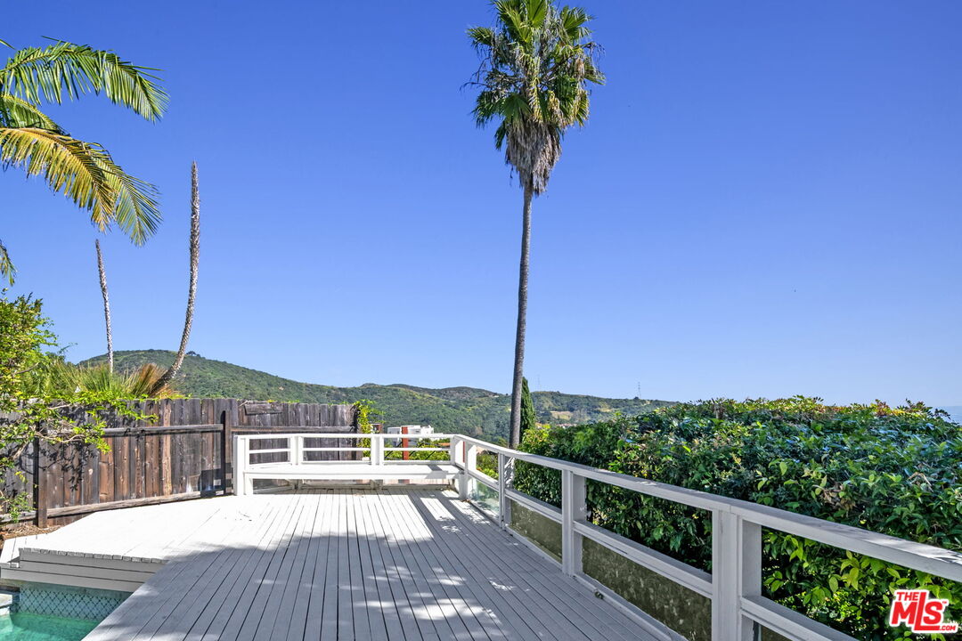 2695 Cordelia Road Los Angeles, CA 90049 - Photo 16 of 33 a view of a balcony with floor to ceiling windows with wooden floor