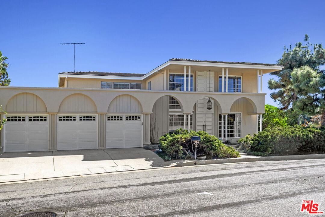 2695 Cordelia Road Los Angeles, CA 90049 - Photo 2 of 33 a front view of a house with a yard and garage