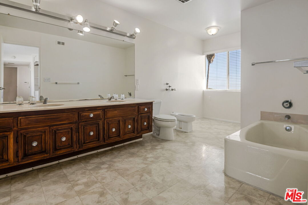 2695 Cordelia Road Los Angeles, CA 90049 - Photo 25 of 33 a spacious bathroom with a tub sink and mirror