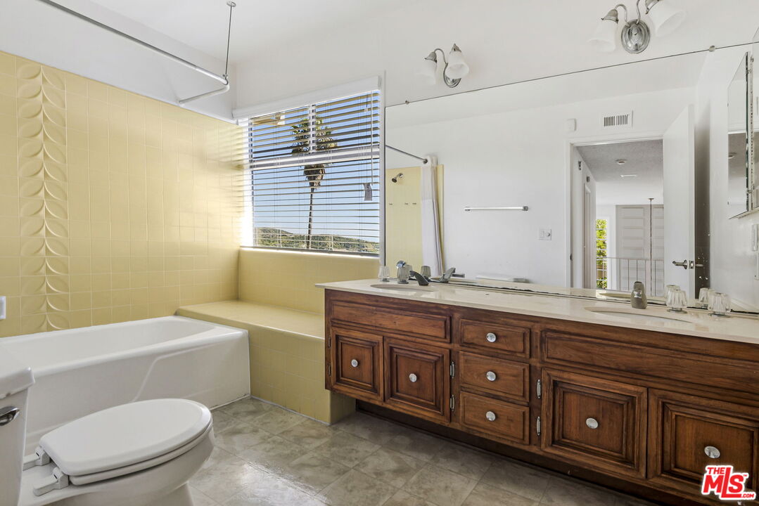 2695 Cordelia Road Los Angeles, CA 90049 - Photo 31 of 33 a bathroom with a granite countertop toilet sink and mirror