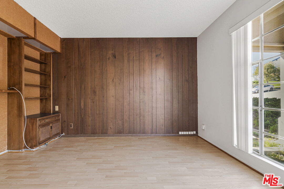2695 Cordelia Road Los Angeles, CA 90049 - Photo 32 of 33 an empty room with wooden floor and cabinet