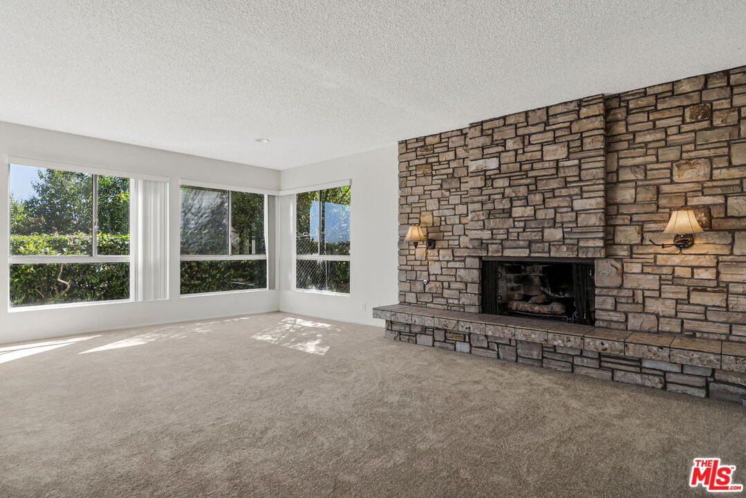 2695 Cordelia Road Los Angeles, CA 90049 - Photo 4 of 33 a view of an empty room with a fireplace and a window