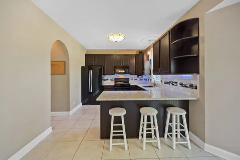 a kitchen with a sink and chairs