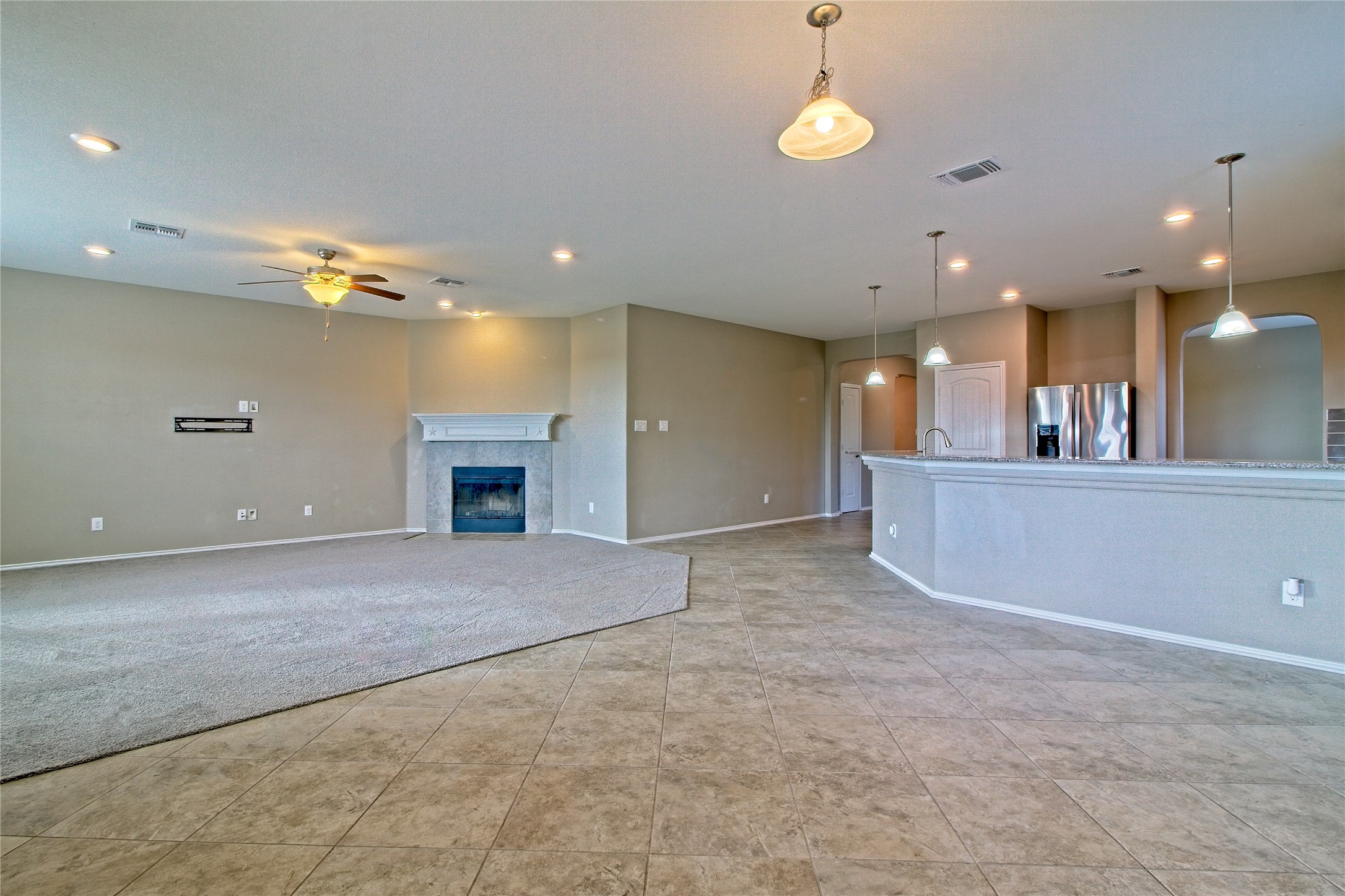 31443 Kingsway Road Georgetown, TX 78628 - Photo 9 of 40 An inviting open-concept living space features a cozy fireplace and seamless flow to the kitchen.