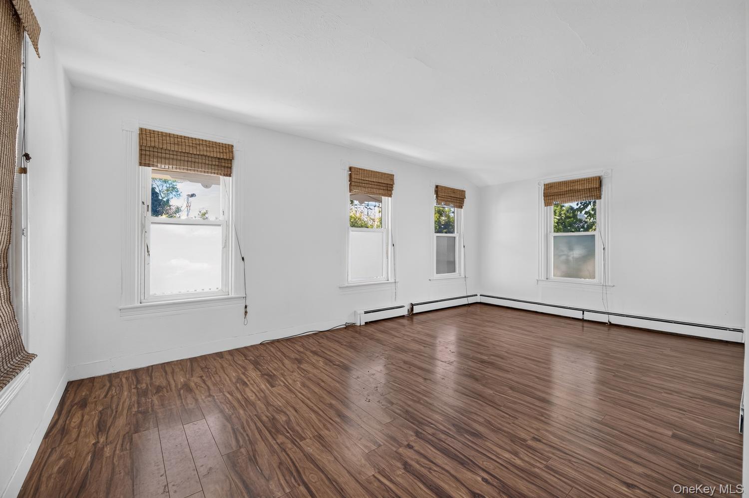 49 Cedar Street Babylon, NY 11702 - Photo 4 of 20 a view of an empty room with wooden floor and a window
