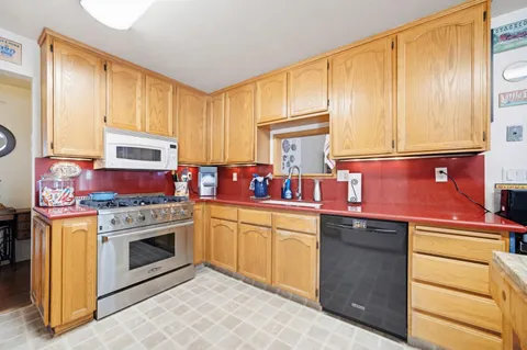 a kitchen with a stove sink and cabinets
