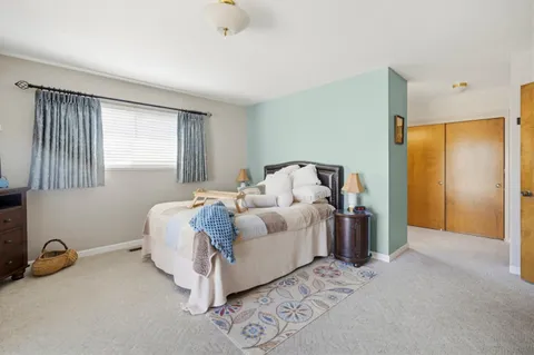 a spacious bedroom with a bed and a dresser