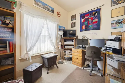 a view of a workspace with furniture and a window