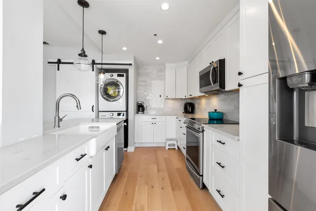 a kitchen with white cabinets stainless steel appliances and sink