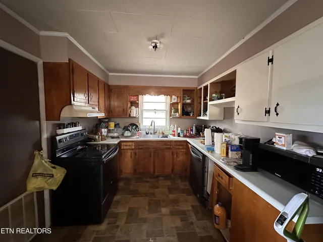 a kitchen with stainless steel appliances granite countertop sink stove top oven and cabinets
