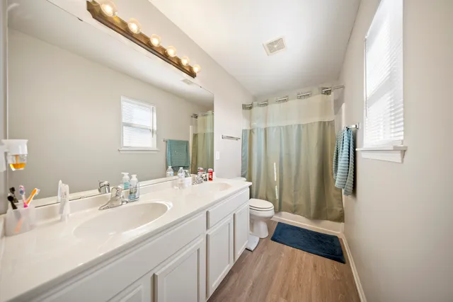 a bathroom with a double vanity sink toilet and shower