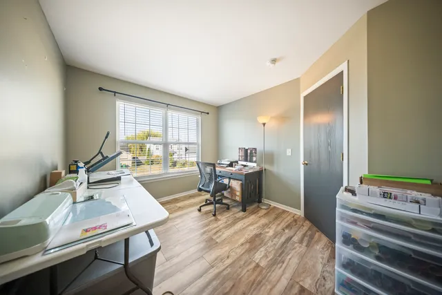 a view of a workspace with furniture and a window