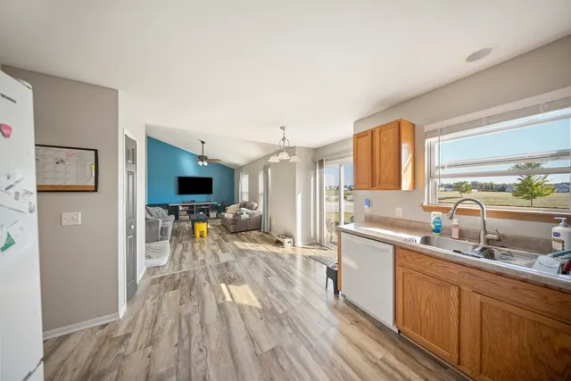 a kitchen with a sink and wooden floor