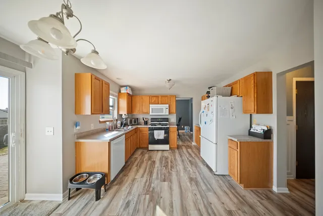 a kitchen with stainless steel appliances granite countertop a refrigerator and a stove top oven