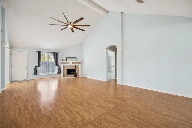 a view of empty room with wooden floor and fireplace