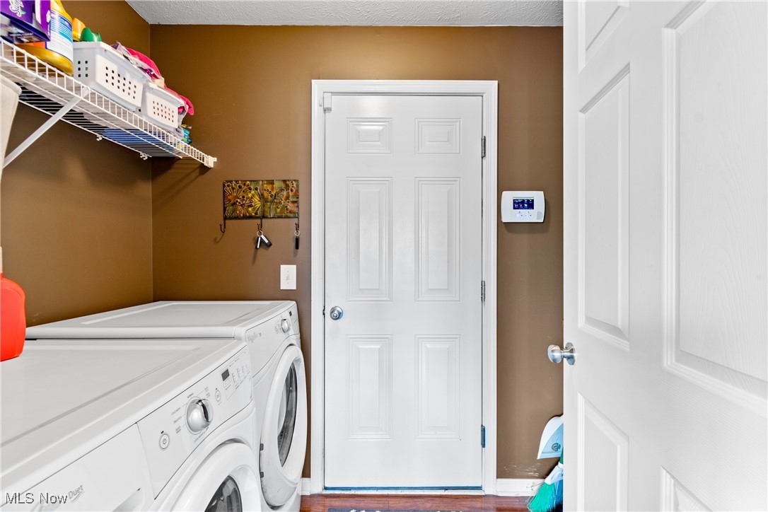 4467 Ridgestone Way Medina, OH 44256 - Photo 13 of 31 Laundry area with hardwood / wood-style flooring, a textured ceiling, and washing machine and clothes dryer