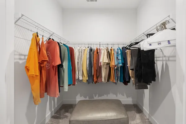 a view of walk in closet with clothes and shoes