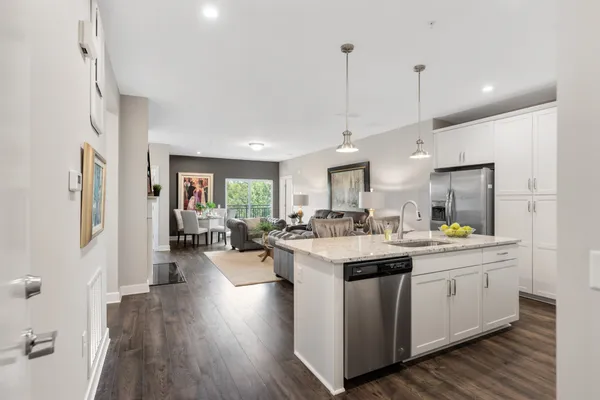 a kitchen with a sink stove and wooden floor
