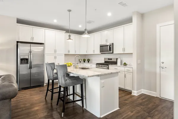 a kitchen with kitchen island granite countertop a sink a center island and stainless steel appliances