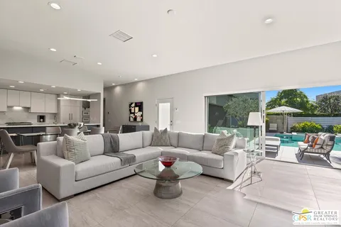 a living room with furniture kitchen and a chandelier