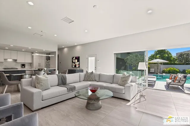 a living room with furniture kitchen and a chandelier