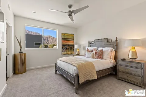 a bedroom with a bed and large window