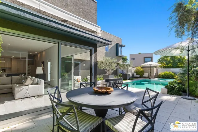 a view of a house with backyard and sitting area