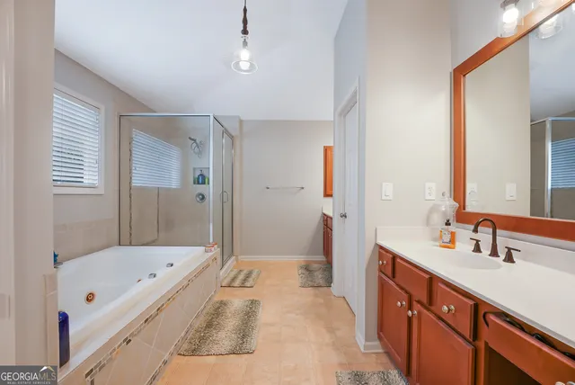 a bathroom with a tub sink and mirror